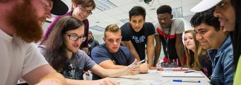 Students and faculty gathered around a table in a student success course